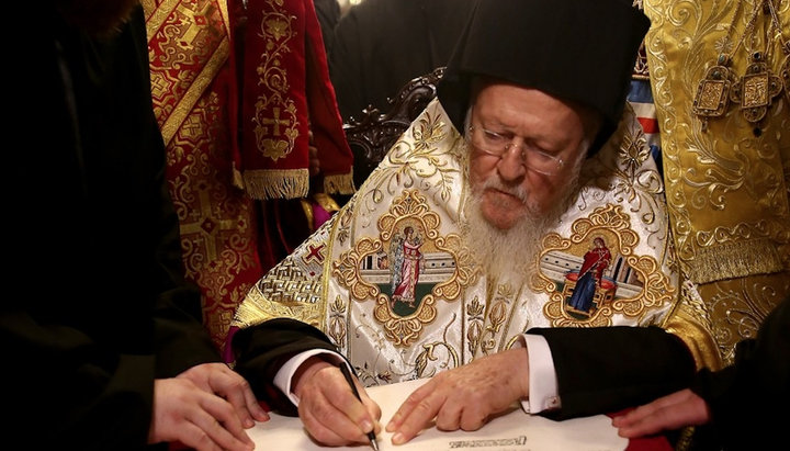 Patriarch Bartholomew signs the Tomos for the OCU. Photo: zik.ua