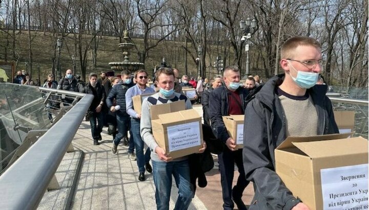 Віряни УПЦ несуть коробки з підписами під зверненням до Зеленського. Фото: СПЖ