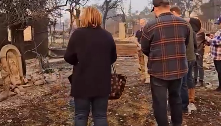 In Los Angeles, a family prays before a statue of the Virgin Mary that survived California wildfire. Photo: Video screenshot