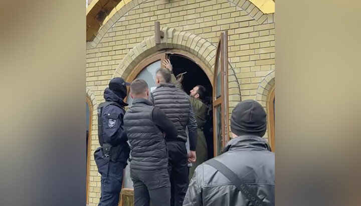 Клирик ПЦУ Засанский взламывает двери Андреевского храма в Черкассах. Фото: СПЖ