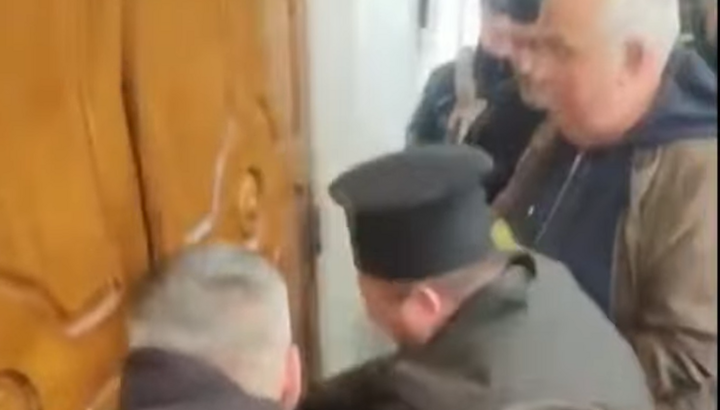 “Priest” of the OCU personally breaks down the door of a UOC church in Zastavna. Photo: Dozor