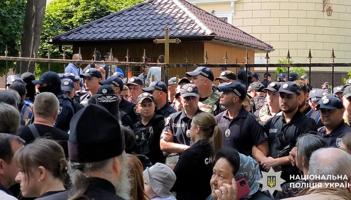 Οι αστυνομικοί φυλάσσουν τους επιδρομείς και δεν επιτρέπουν στους πιστούς της Ουκρανικής Ορθόδοξης Εκκλησίας να εισέλθουν στον καθεδρικό τους ναό στο Τσερνιβτσί. Φωτογραφία: cv.npu.gov