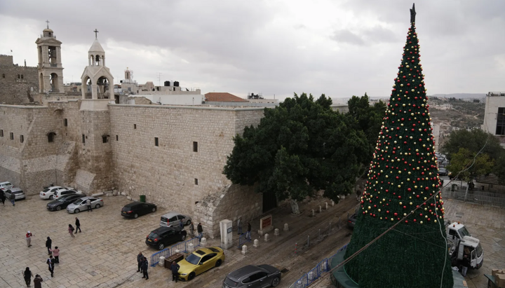 Рабочие устанавливают рождественскую ёлку на площади рядом с церковью Рождества Христова в Вифлееме, 25 ноября 2025г. Фото: AP Photo/Mahmoud Illean